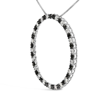 White metal necklace in a circular pendant shape set with alternating black and white round gemstones in prong settings, shown in a close-up angled shot.