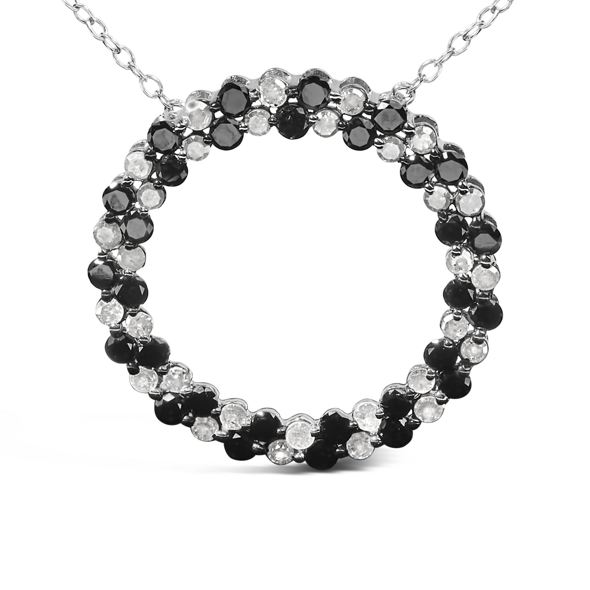 Close-up front view of a white metal necklace pendant featuring a circular design with alternating round black and white gemstones in prong settings.