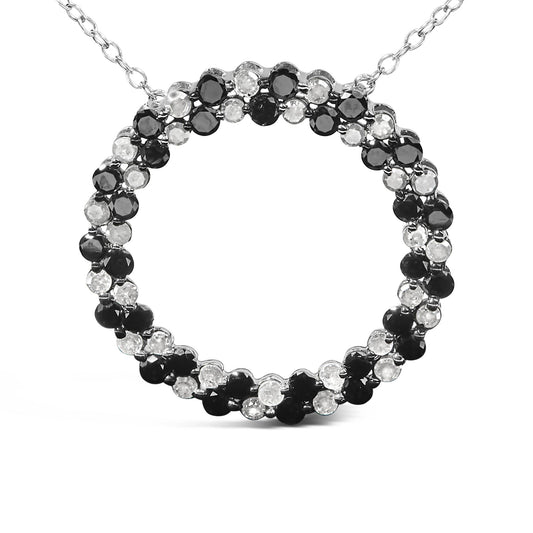 Close-up front view of a white metal necklace pendant featuring a circular design with alternating round black and white gemstones in prong settings.