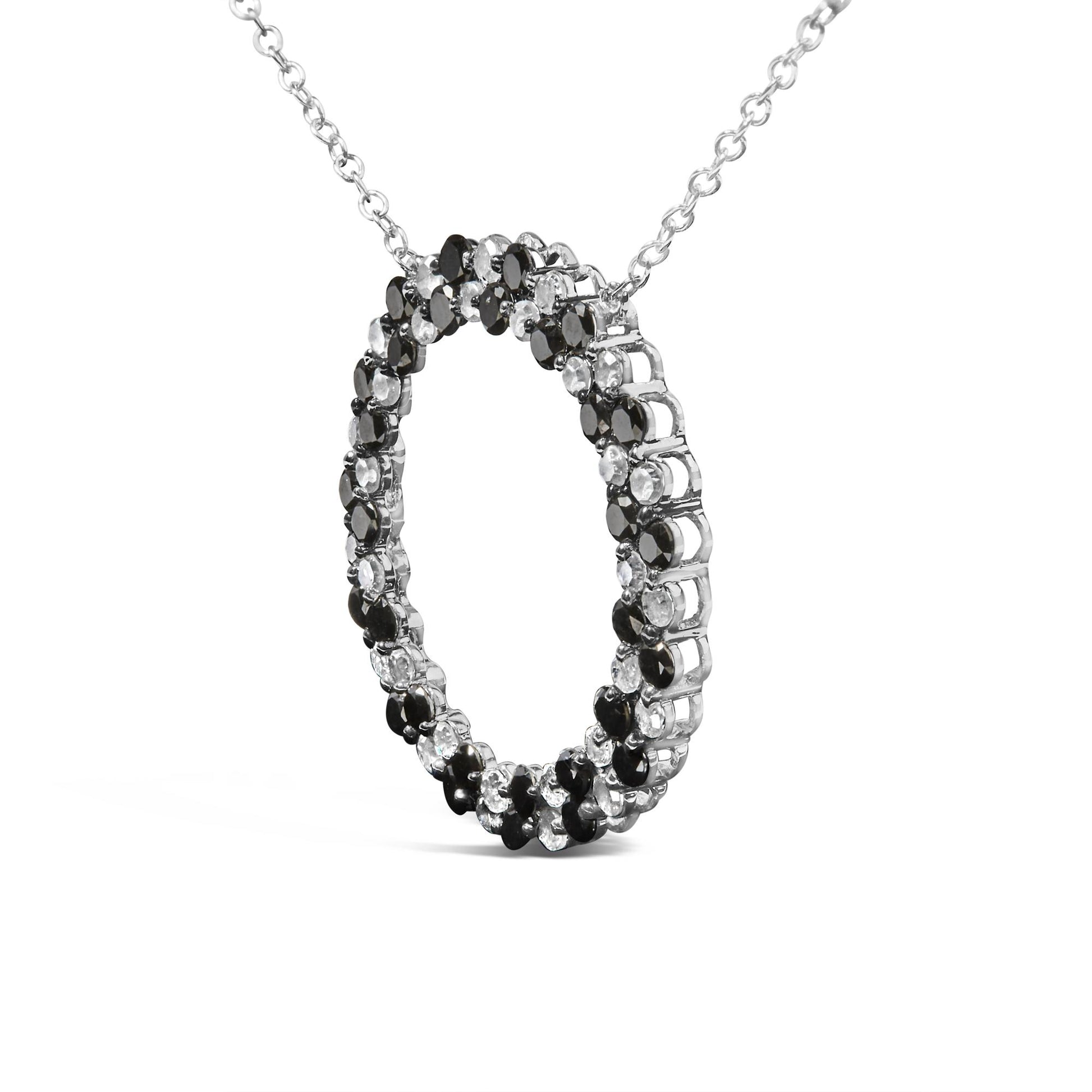 White necklace with a circular pendant featuring alternating black and white round gemstones in prong settings, shown at a slight angle.