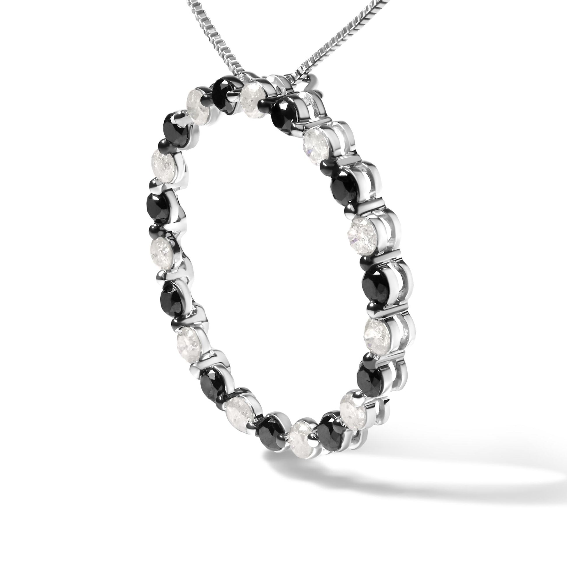 Close-up angled shot of a white metal circular necklace pendant featuring alternating round white and black gemstones in prong settings, suspended from a white metal chain.