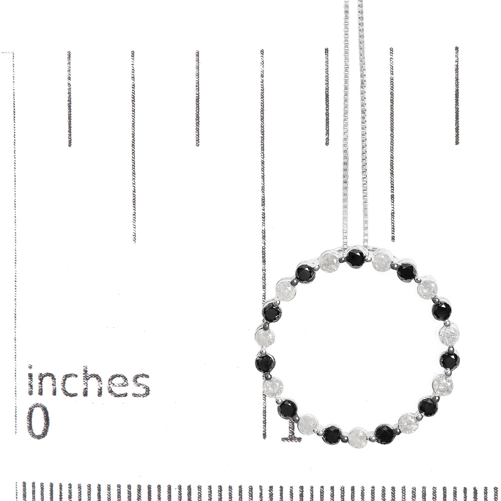 White metal necklace displayed on a ruler for size reference, featuring a circular pendant with alternating round black and white gemstones in prong settings, shown from the front angle.