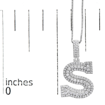 Close-up front angle of a white metal necklace with an 'S'-shaped pendant encrusted with round white gemstones, shown on a scale.