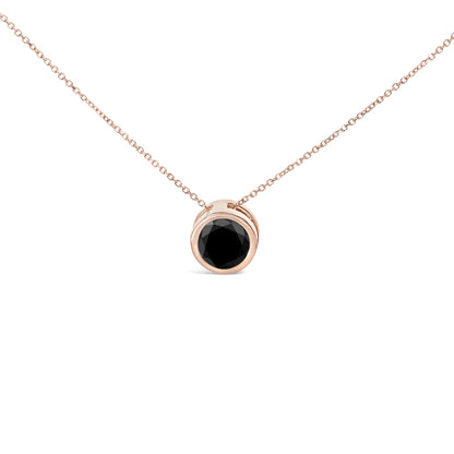 Front angle close-up of a rose metal necklace with a pendant featuring a round black gemstone in a bezel setting.