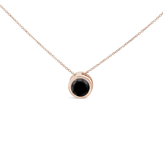 Front angle close-up of a rose metal necklace with a pendant featuring a round black gemstone in a bezel setting.