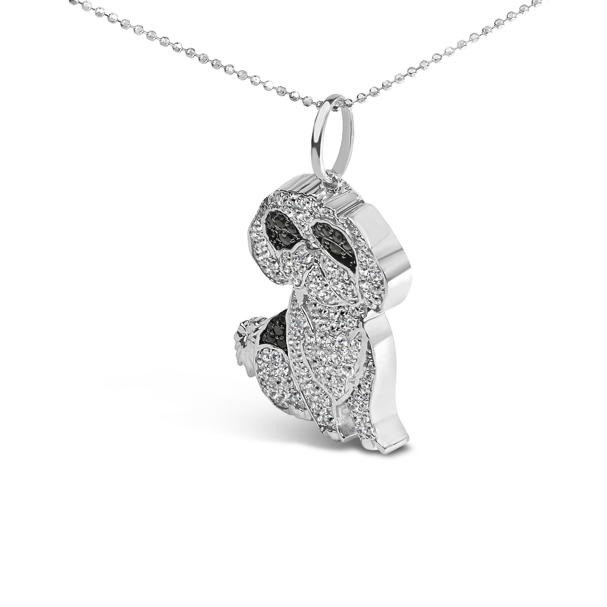 White metal necklace with a pendant shaped like a dog, detailed with micro-pave white and black round gemstones, shown in a close-up side angle.