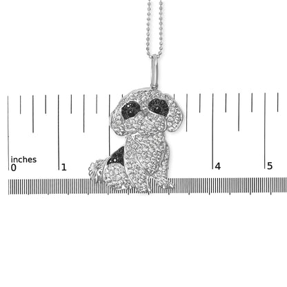 Front-facing shot of a white metal necklace pendant shaped like a sitting dog, adorned with white and black round micro-pave set gemstones, placed on a ruler for size reference.