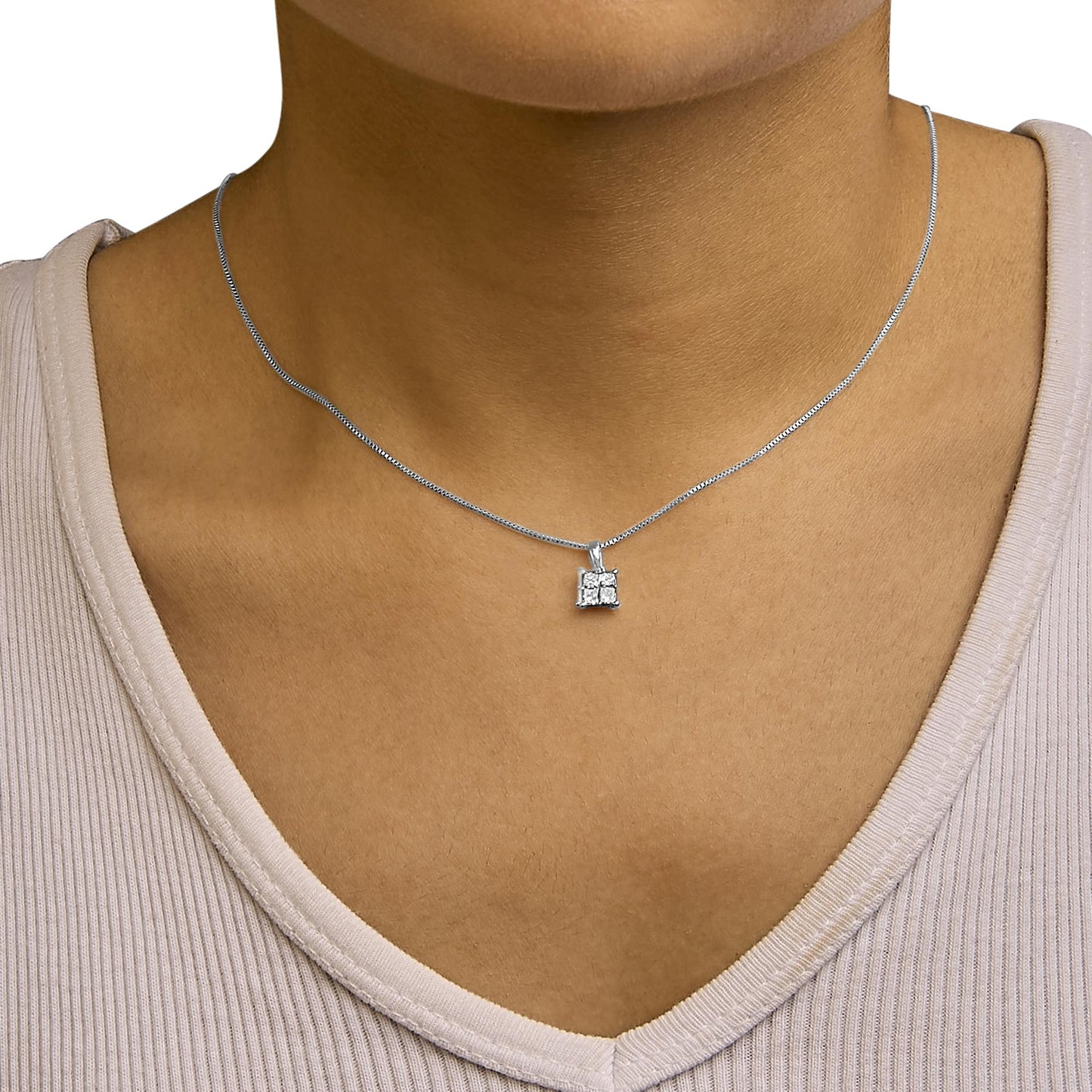 Necklace with a square pendant featuring four princess-shaped white gemstones in an invisible setting, shown worn on a model, front angle.