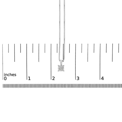 White necklace with princess shape white gemstones in invisible setting, shown hanging centered on a ruler measuring inches, front view.