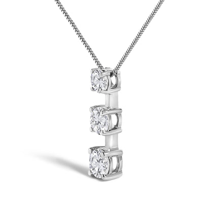 Close-up angled view of a white metal necklace with a vertical pendant featuring three round white gemstones set in prong and miracle settings.