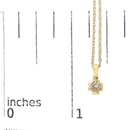 Close-up front view of a yellow metal necklace with a round white gemstone in a prong setting pendant, shown on a scale marked in inches.