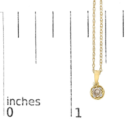Yellow metal necklace with a round white gemstone in a prong setting pendant, shown hanging vertically on a scale with inch markings, front view.