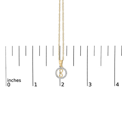 Close-up front view of a yellow metal necklace pendant with an infinity symbol surrounded by a circle of white gemstones, shown on a scale.