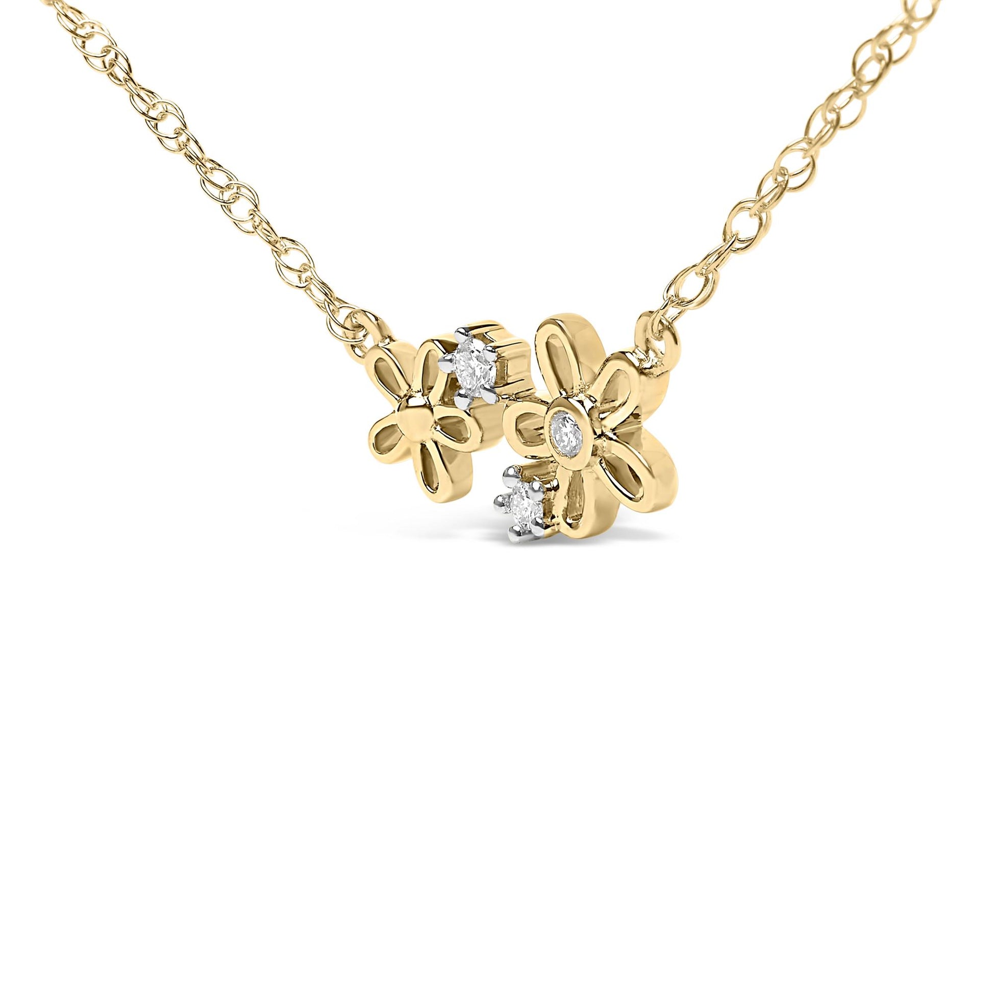 Close-up front angled view of a yellow metal necklace with two flower-shaped pendants, each featuring white round gemstones in prong settings.