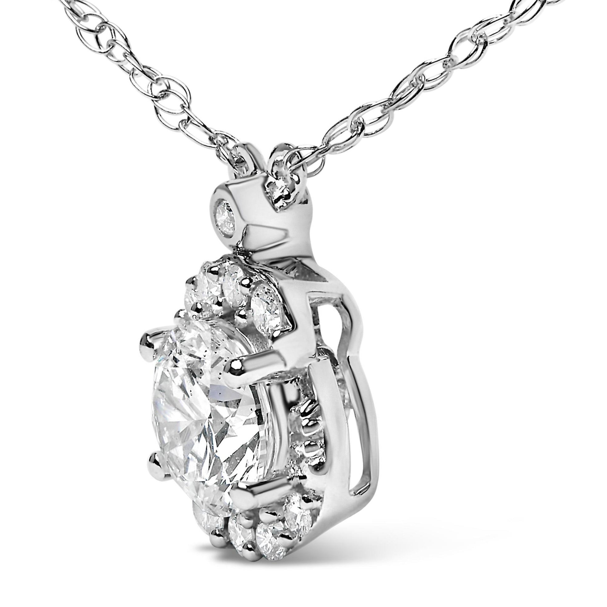 Close-up angled view of a white metal necklace pendant featuring a large round white gemstone centered and surrounded by smaller round white gemstones in a prong setting, hanging from a linked chain.