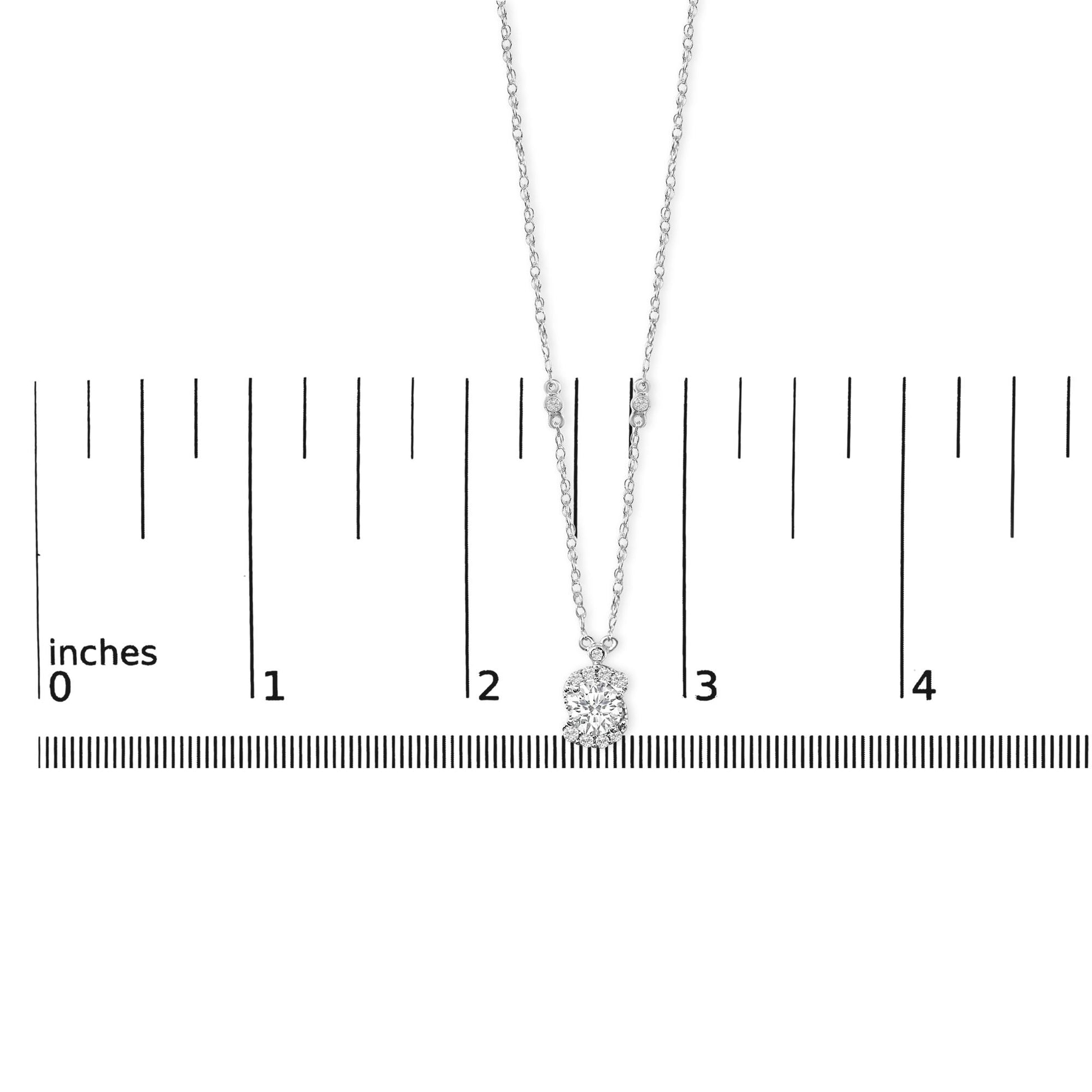 Necklace with a pendant featuring multiple round white gemstones in prong settings, shown on a scale from a front angle.