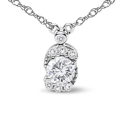 Close-up front view of a white metal necklace with a pendant featuring one large round white gemstone surrounded by multiple smaller round white gemstones, all in prong settings. The pendant is shown hanging on a chain.