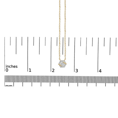 Yellow metal necklace with a hexagonal-shaped pendant featuring one large round white gemstone and surrounding smaller round white gemstones, shown on a ruler scale from a top-down angle.
