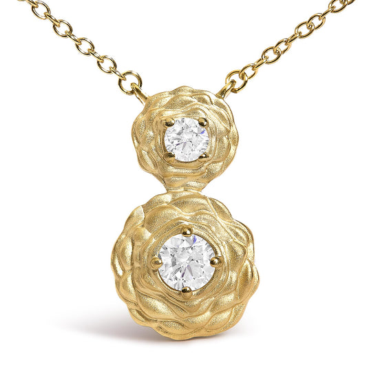 Close-up front view of a yellow metal necklace with two flower-shaped pendants, each set with a round white gemstone in a four-prong setting.