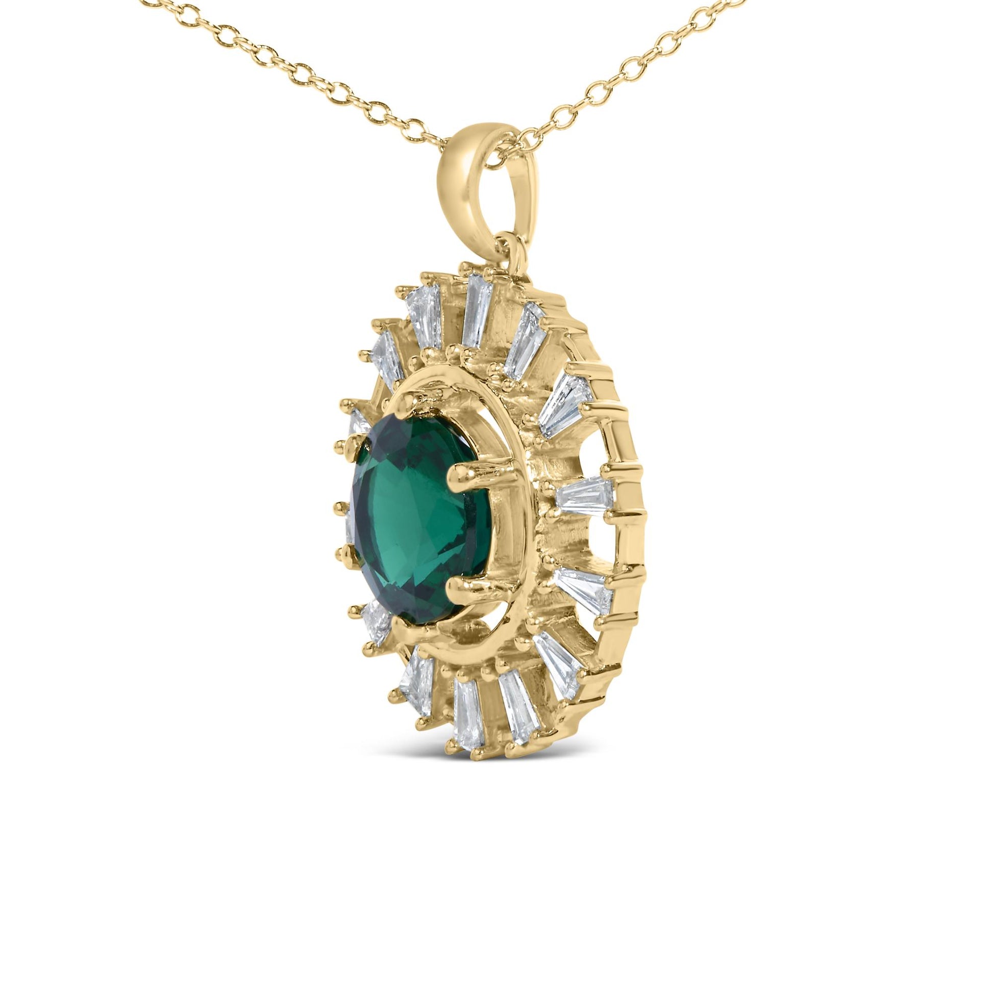Close-up front angle of yellow metal necklace pendant featuring a large green round gemstone center surrounded by white baguette-shaped gemstones in prong settings.
