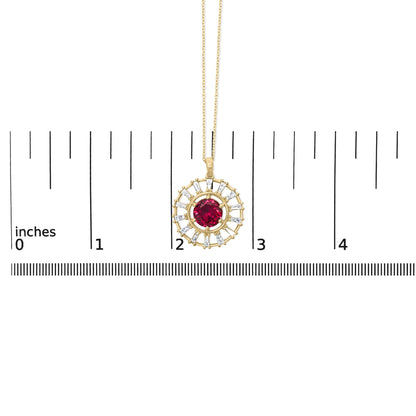 Close-up front view of a yellow metal necklace pendant with a round red gemstone center surrounded by baguette-shaped white gemstones, shown on a scale.