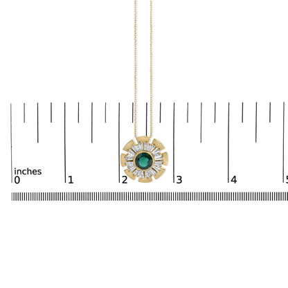 Close-up front view of a yellow metal necklace pendant shown on a scale. The pendant is circular with a large round green gemstone in the center, surrounded by a ring of white baguette-shaped gemstones in prong settings, and yellow metal fan-shaped accents around the edge. The pendant hangs from a fine chain.