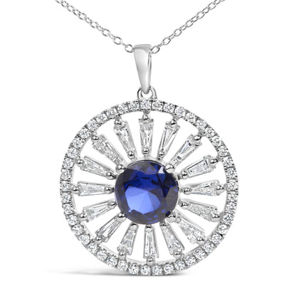 Close-up front view of a white metal necklace pendant featuring a central round blue gemstone surrounded by radiant baguette and round white gemstones in prong settings.