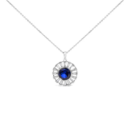 Close-up front view of a white metal necklace pendant featuring a round blue gemstone in the center surrounded by a circular arrangement of white baguette-shaped gemstones in channel settings.