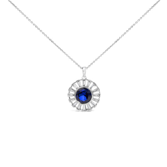 Close-up front view of a white metal necklace pendant featuring a round blue gemstone in the center surrounded by a circular arrangement of white baguette-shaped gemstones in channel settings.