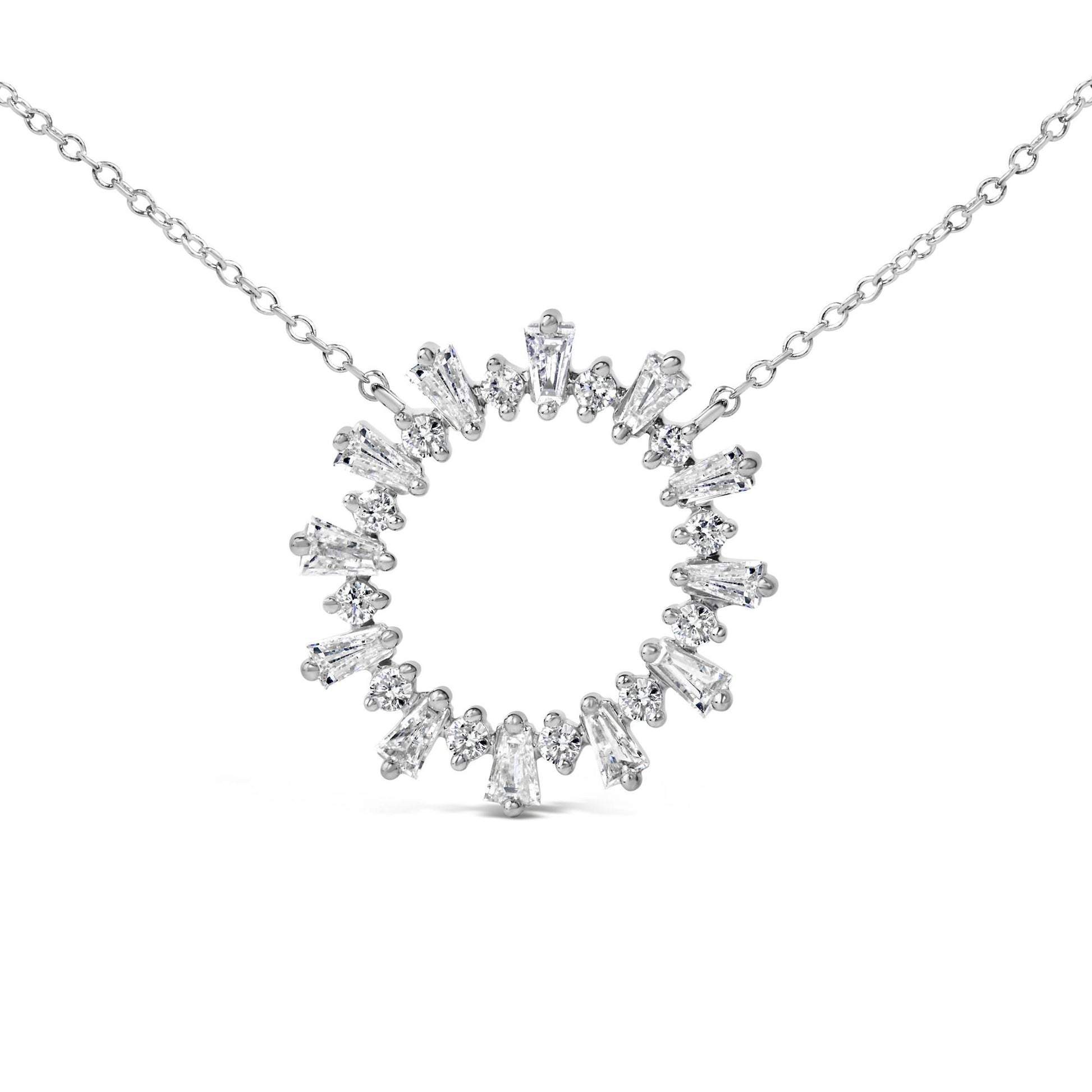 Close-up front angle of a white metal necklace pendant in a circular shape, set with alternating baguette and round white gemstones, shown on a white background.
