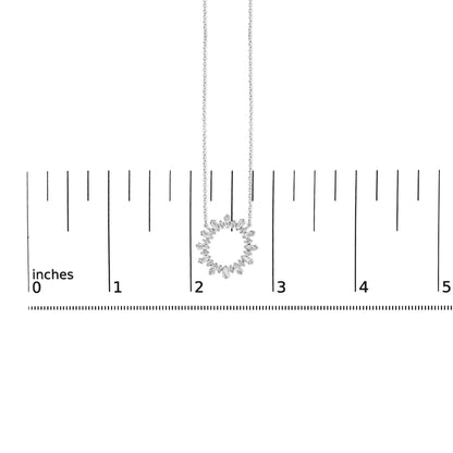 Image showing a white necklace with a circular pendant made of alternating baguette and round white gemstones in prong settings, displayed on a ruler scale, shot from the front angle.