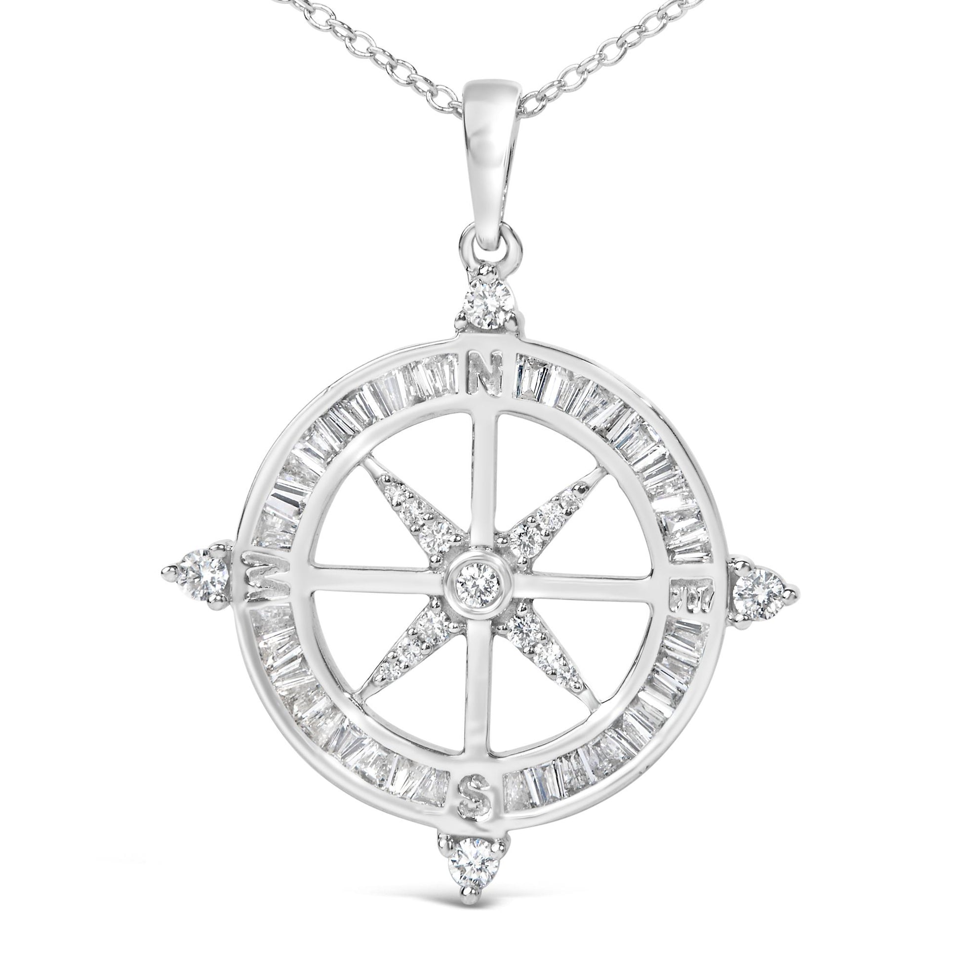 Close-up front view of a white metal compass pendant necklace featuring white baguette-shaped gemstones in a channel setting around the outer circle and white round-shaped gemstones in prong settings at the four cardinal points and center.