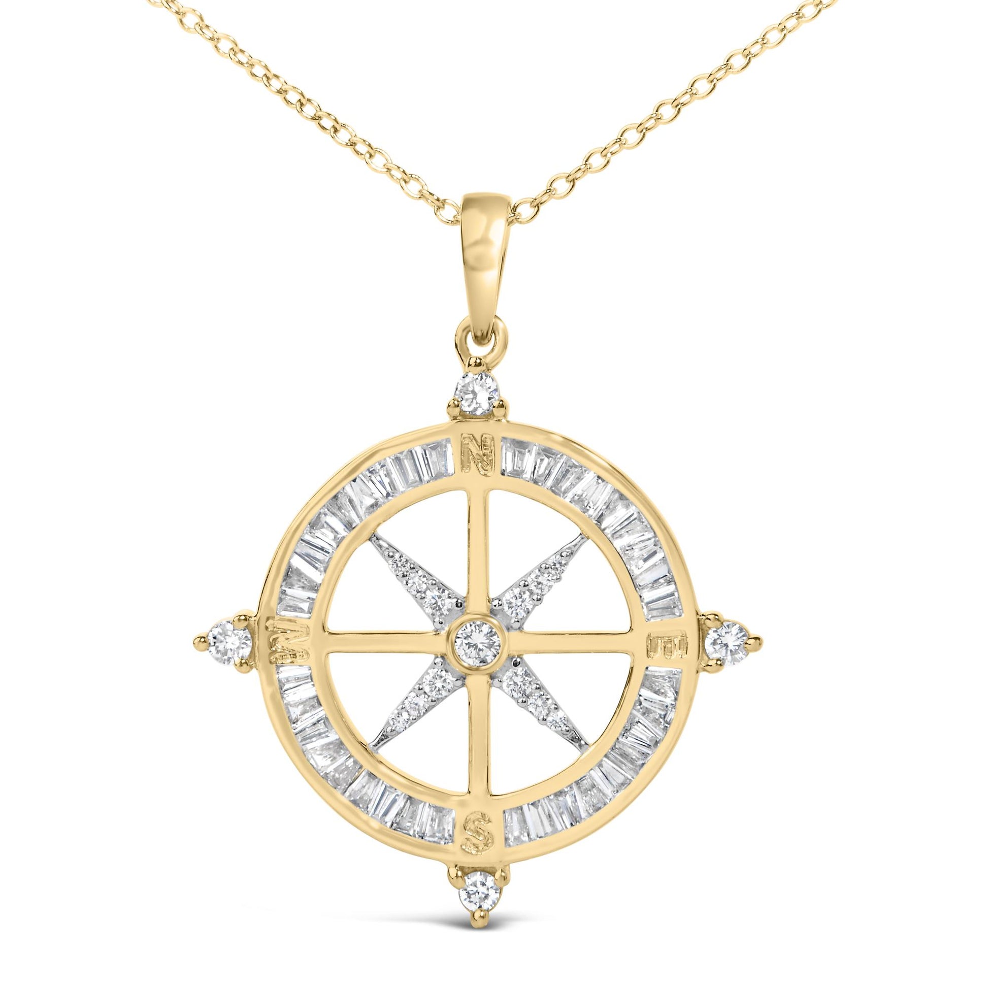 Close-up front view of a yellow metal necklace pendant shaped like a compass with baguette-shaped white gemstones set in a channel around the circle and prong-set round white gemstones at compass points and center, shown on a white background.