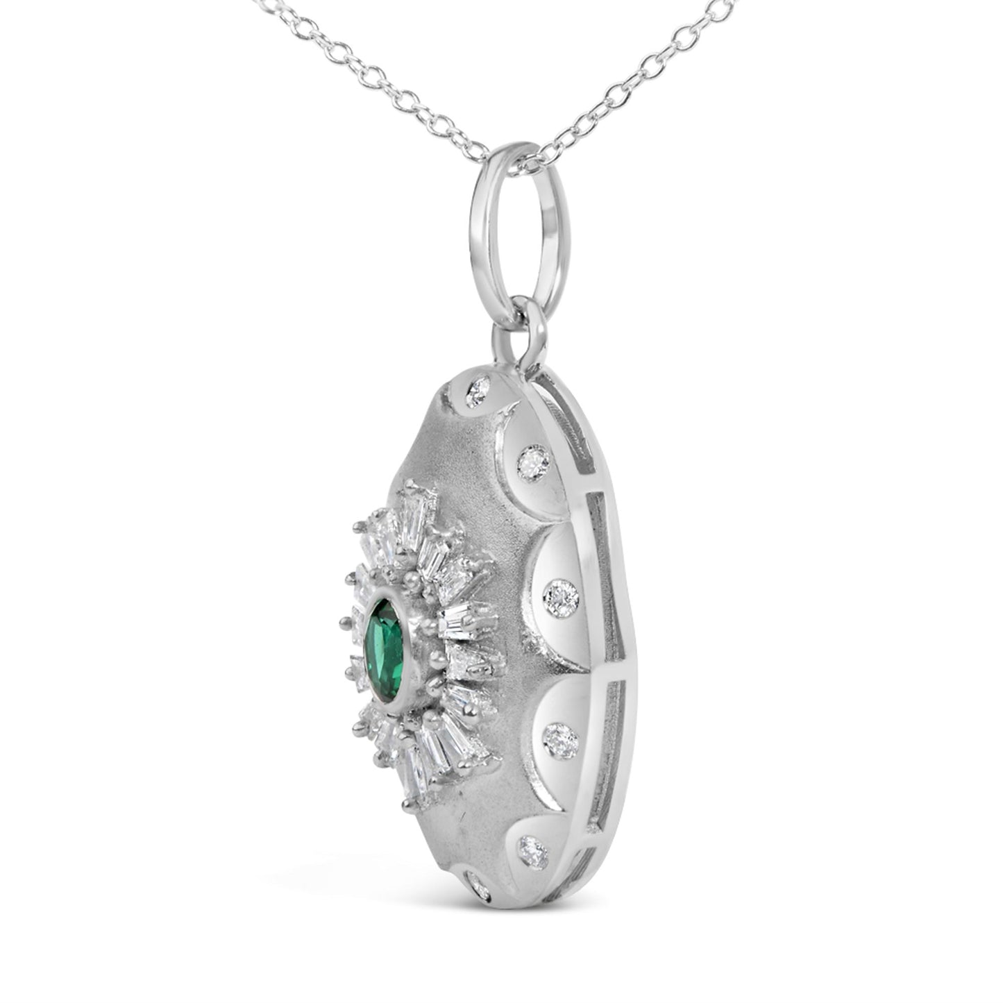 Close-up front angle of a white metal necklace pendant featuring a central oval green gemstone surrounded by white baguette and round shaped gemstones in prong and bezel settings.