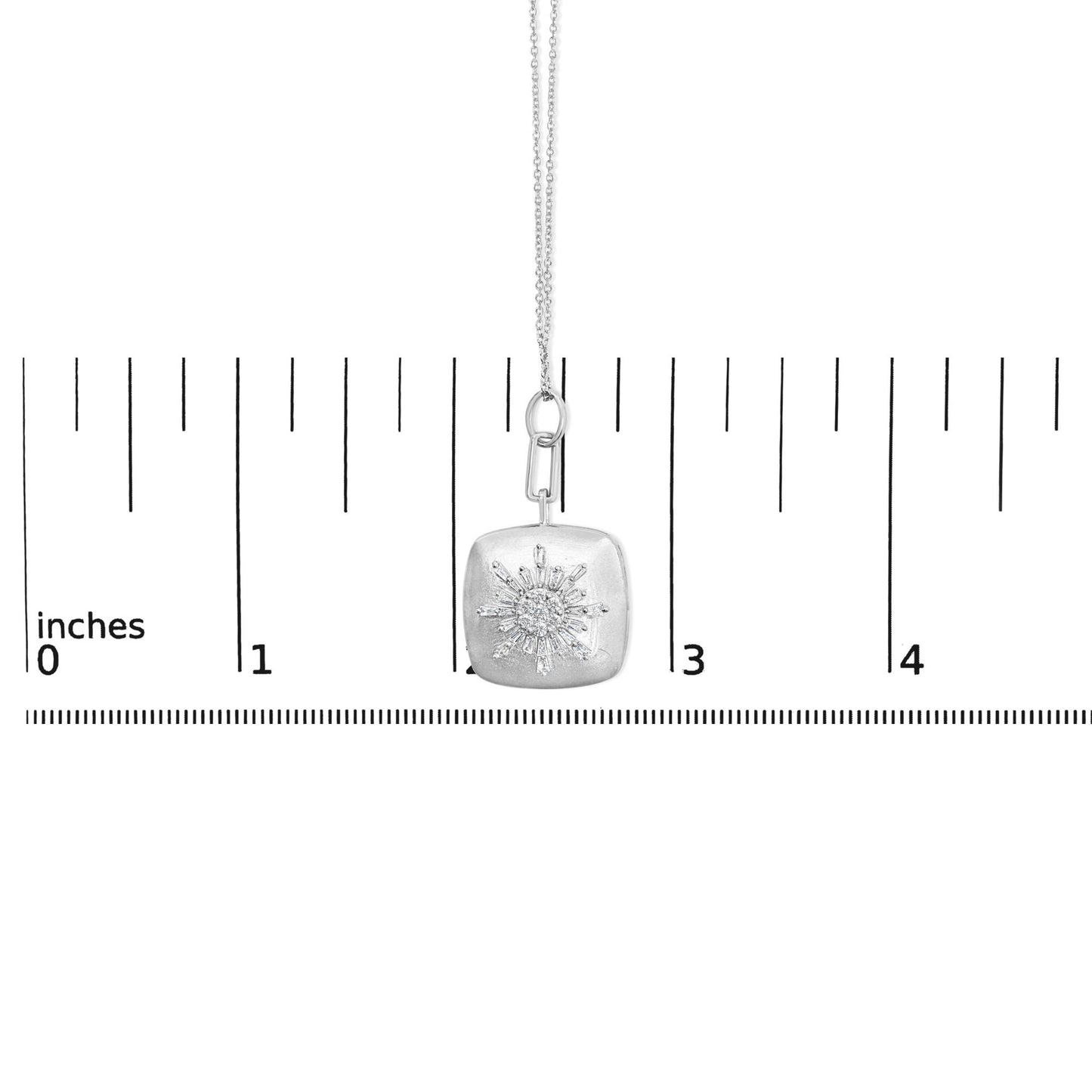 White necklace with a square pendant featuring a sunburst design of baguette and round white gemstones, prong set, shown on a ruler scale, front angled view.