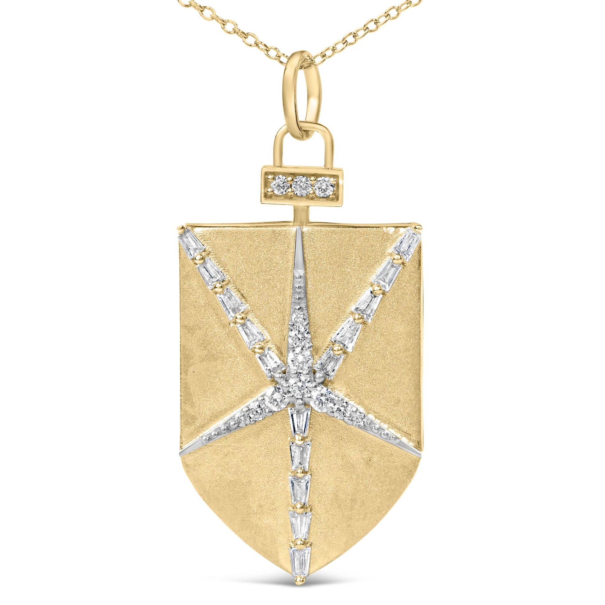 Close-up front view of a yellow metal shield-shaped necklace pendant featuring a starburst pattern of white round and baguette-shaped gemstones in prong settings, shown on a white background.
