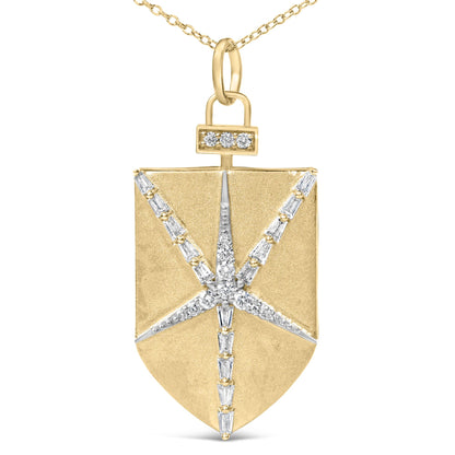 Close-up front view of a yellow metal shield-shaped necklace pendant featuring a starburst pattern of white round and baguette-shaped gemstones in prong settings, shown on a white background.