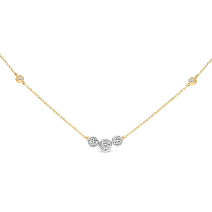 Close-up front view of a yellow metal necklace with a cluster of round white gemstones in bezel settings at the center, shown against a white background.