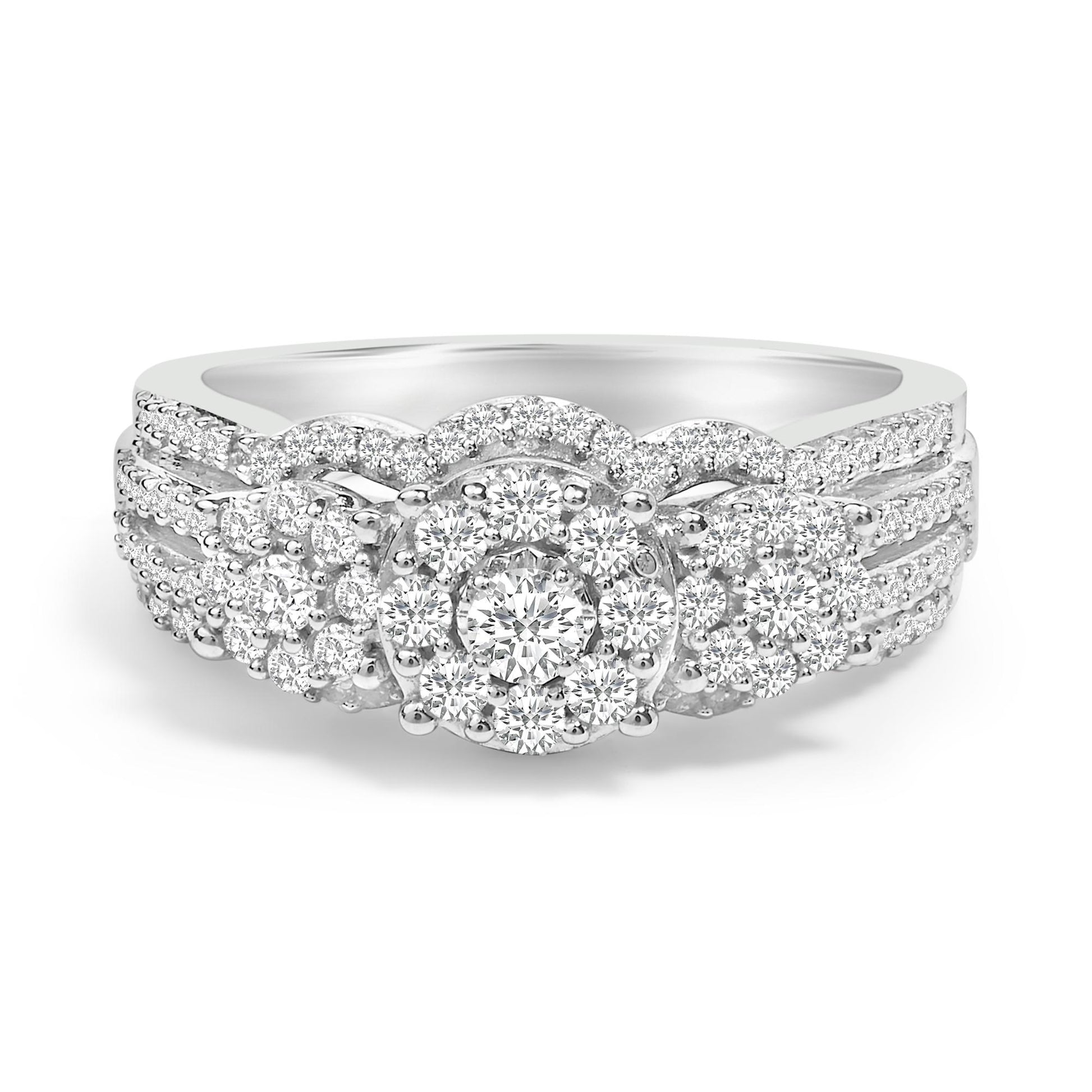 Front-facing close-up of a white metal ring featuring a round prong-set white gemstone in the center, surrounded by multiple smaller round prong-set white gemstones in a decorative cluster pattern. The band is adorned with rows of small round prong-set white gemstones.