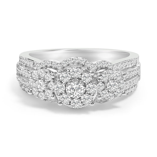 Front-facing close-up of a white metal ring featuring a round prong-set white gemstone in the center, surrounded by multiple smaller round prong-set white gemstones in a decorative cluster pattern. The band is adorned with rows of small round prong-set white gemstones.