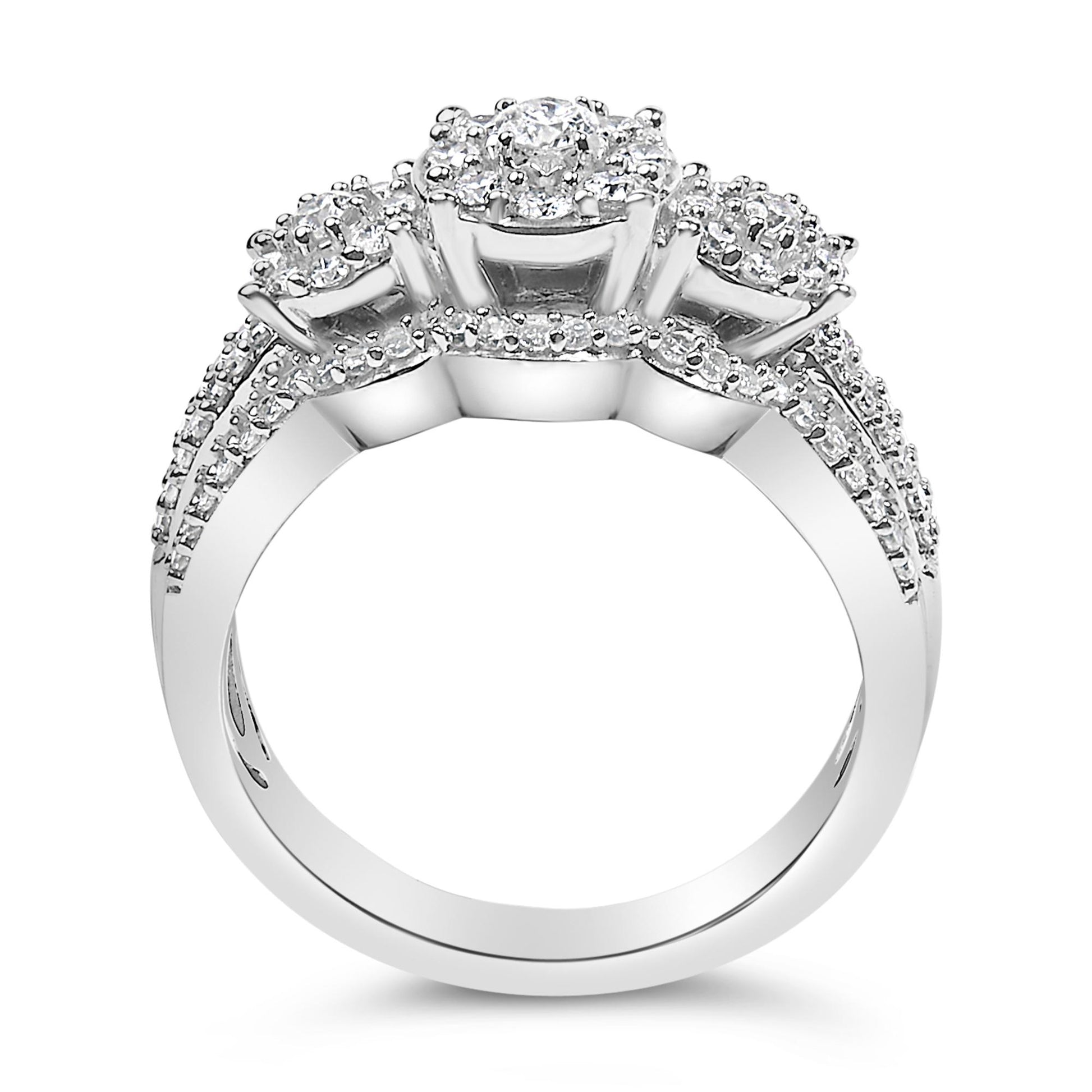 Close-up front view of a white metal ring featuring three clusters of round white gemstones in prong settings, with additional smaller round white gemstones decorating the band.