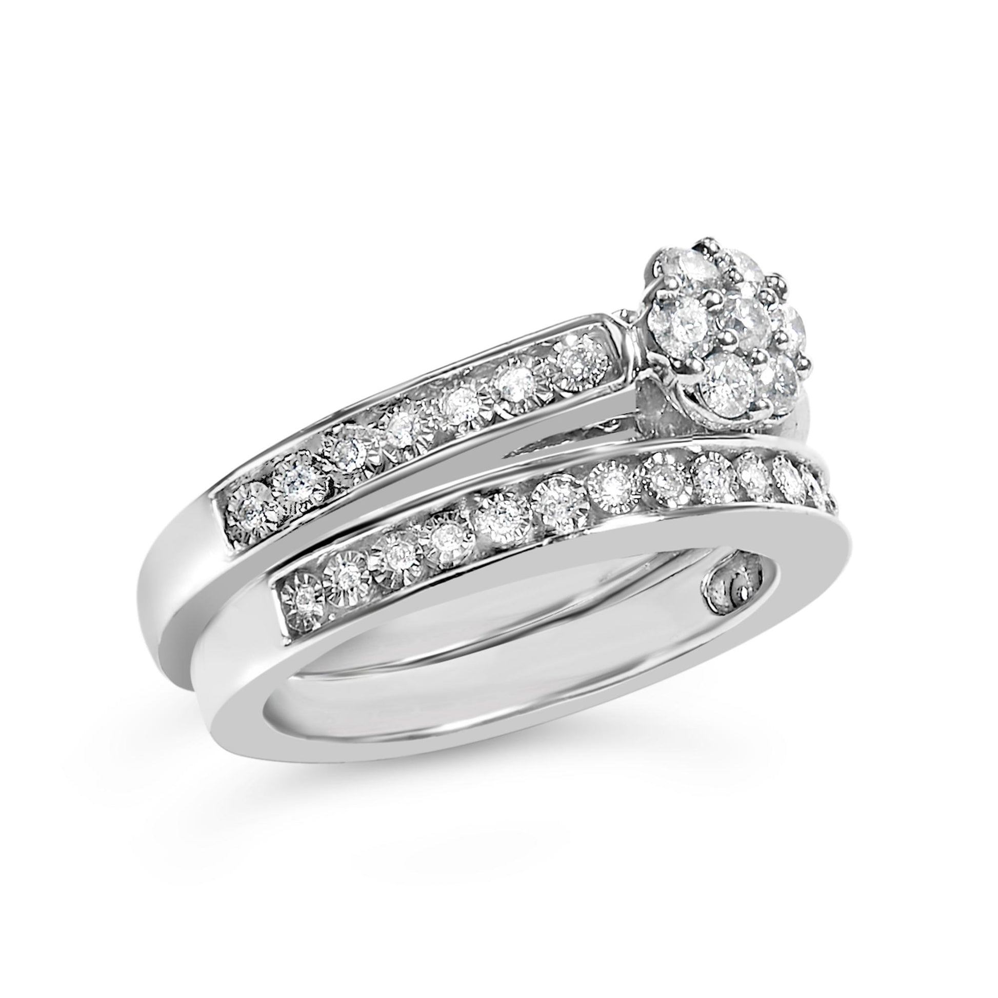 Close-up front-side angle of a white metal ring featuring two bands adorned with multiple small round white gemstones in prong settings, and a cluster of round white gemstones on top.