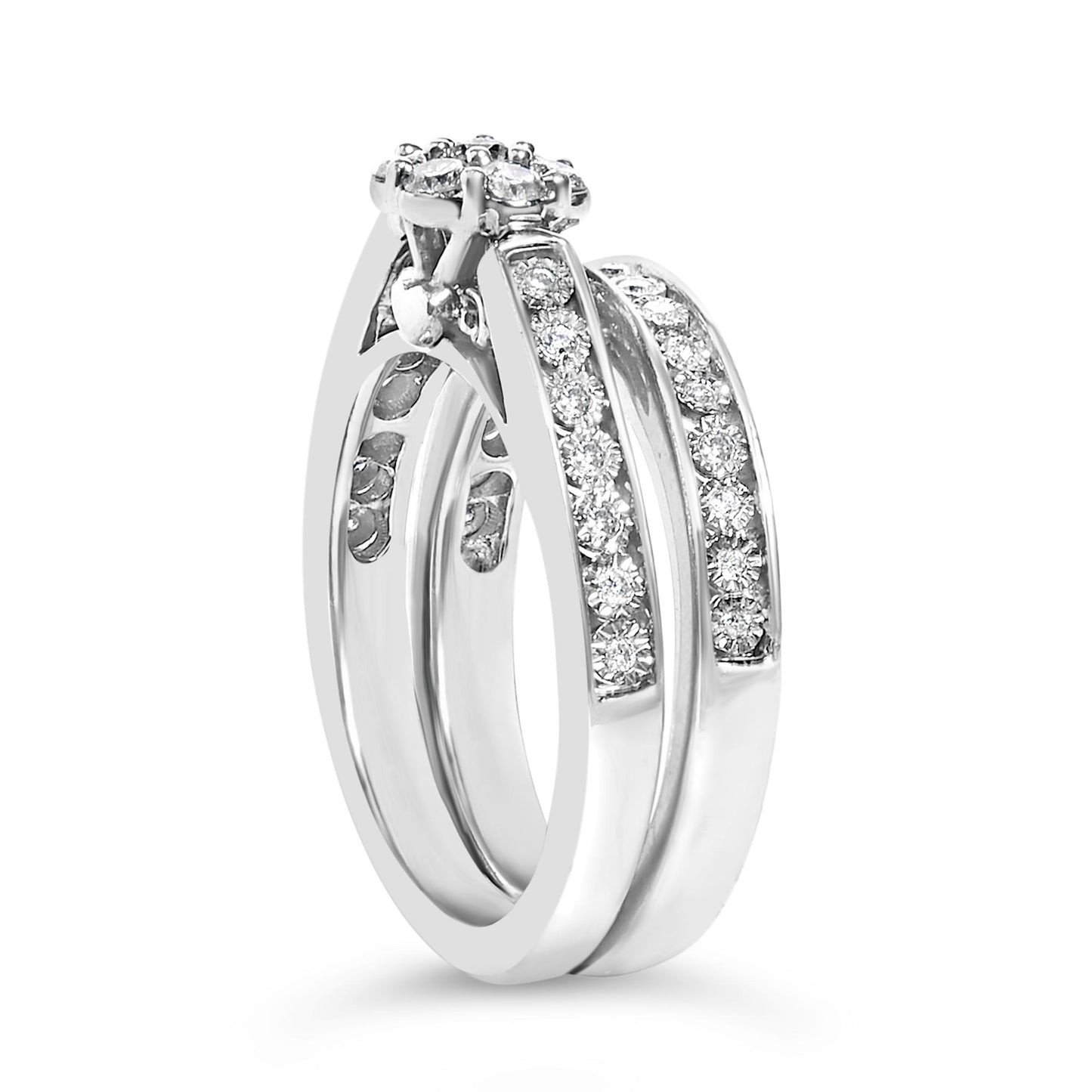 White metal ring shown in a close-up angled view, featuring round white gemstones in prong settings along the band and a raised cluster setting at the top.