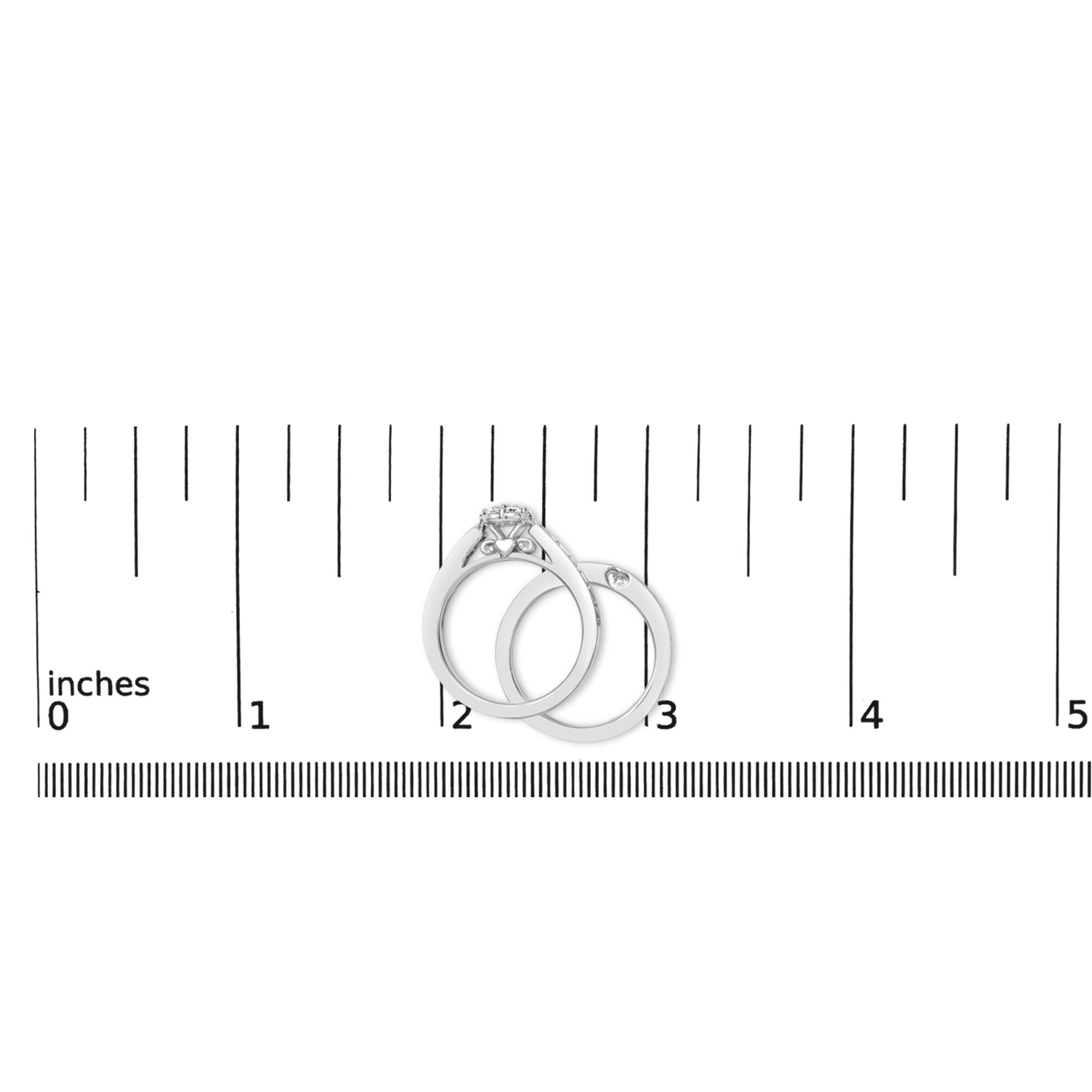 Two white metal rings with round white gemstones in prong settings, shown on a scale, photographed from the top angle.