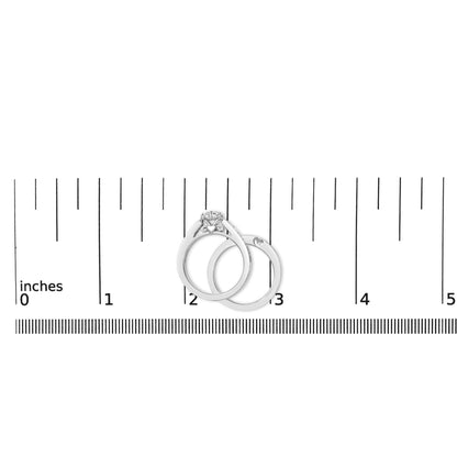Two white metal rings with round white gemstones in prong settings, shown on a scale, photographed from the top angle.