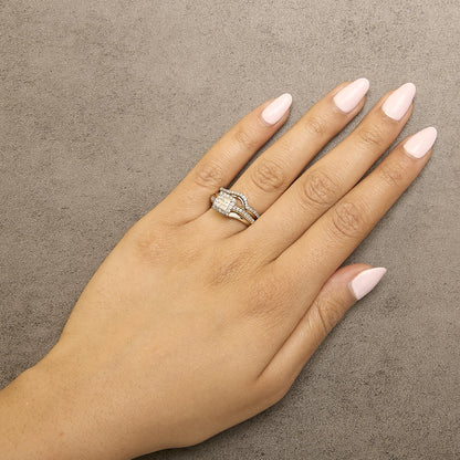 Yellow and white metal ring with princess shape and round shape white gemstones, shown worn on a model's hand from a top-down angle.