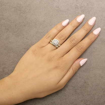 Ring with a square cluster of white round gemstones in prong setting and a split shank design in yellow and white metal, shown worn on a model’s hand from above at an angle.