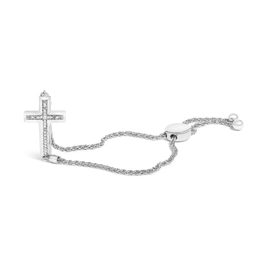 White bracelet with a cross pendant featuring white round gemstones in a pave setting, shown from a side angle on a white background.
