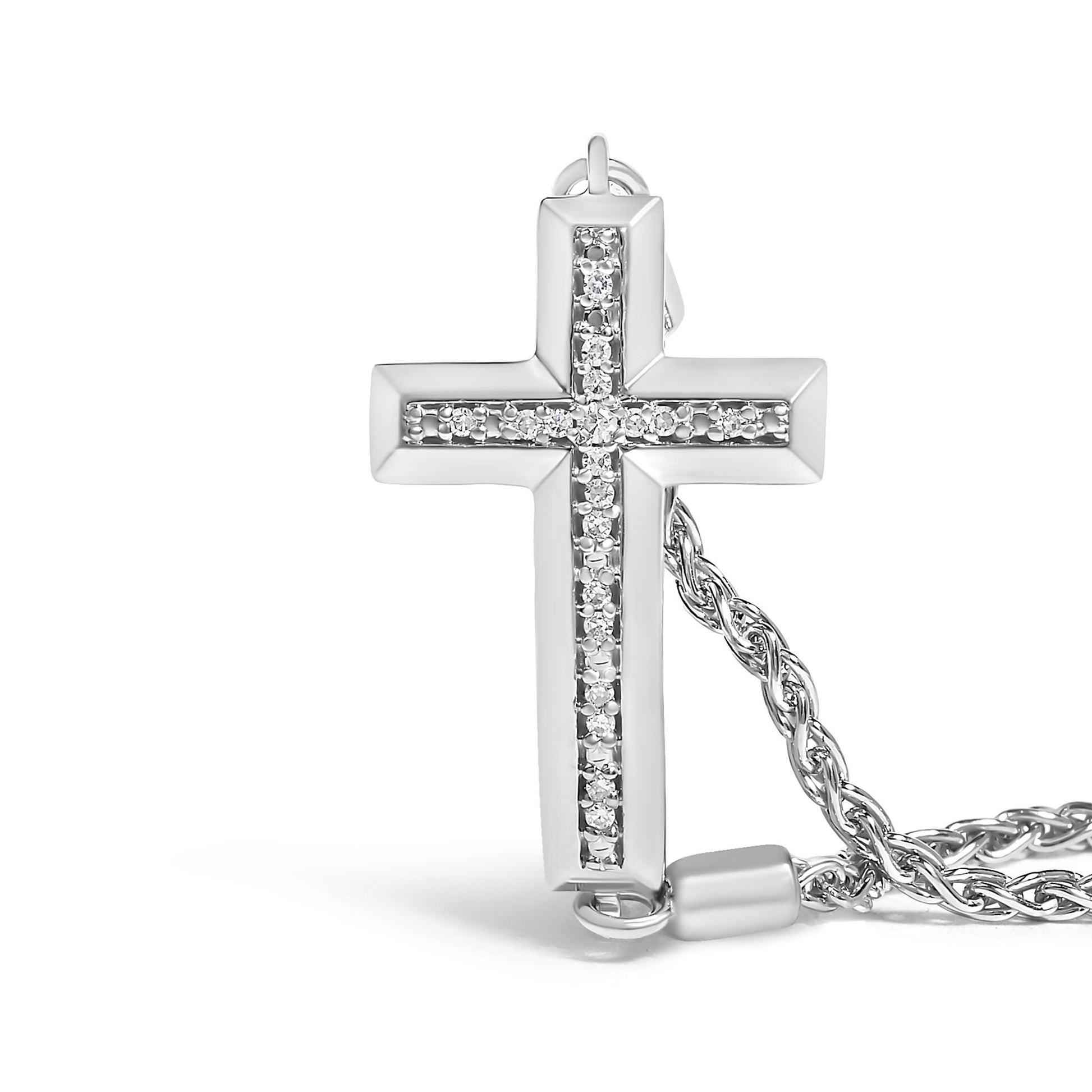 Close-up front angle of a white metal cross-shaped bracelet pendant with a vertical and horizontal line of white round pave-set gemstones, shown with part of a twisted chain.