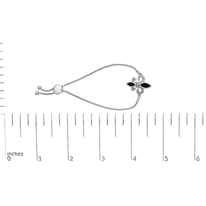 White metal bracelet with two black marquise-shaped gemstones and small white round gemstones in pave setting, shown on a ruler for size reference, top down view.